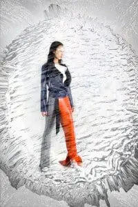 Anita wears grey bell bottoms by Maria Dora, white chest piece by Mother of London, blue leather jacket by Harold Kensington, orange leg panel by Harold Kensington, heeled shoes by Alpel, gold ring by Charles Albert, alain resnais