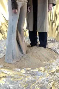 Je t'aime by Taner Tumkaya: Mark wears tan coat and black trousers by Harold Kensington, boots by Old Gringo, jacket by Nine Muses, gold ring by Charles Albert Anita wears tan knitted bell bottoms by Maria Dora, shear pucker dress by Genevieve Clifford, black neck panel and dark brown glove by Mother of London, gold ring by Charles Albert