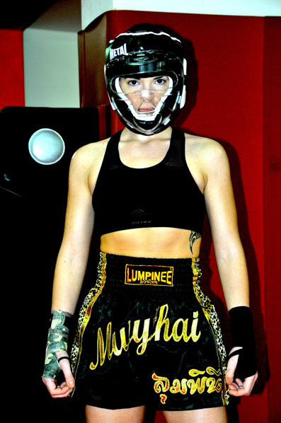 Kick Boxing Fashion: Emanuela wears kick boxing head guard by Lion , top by Nike, boxing shorts by Lumpinee, black gloves by Dimensione Danza, mimetic gloves by Twins